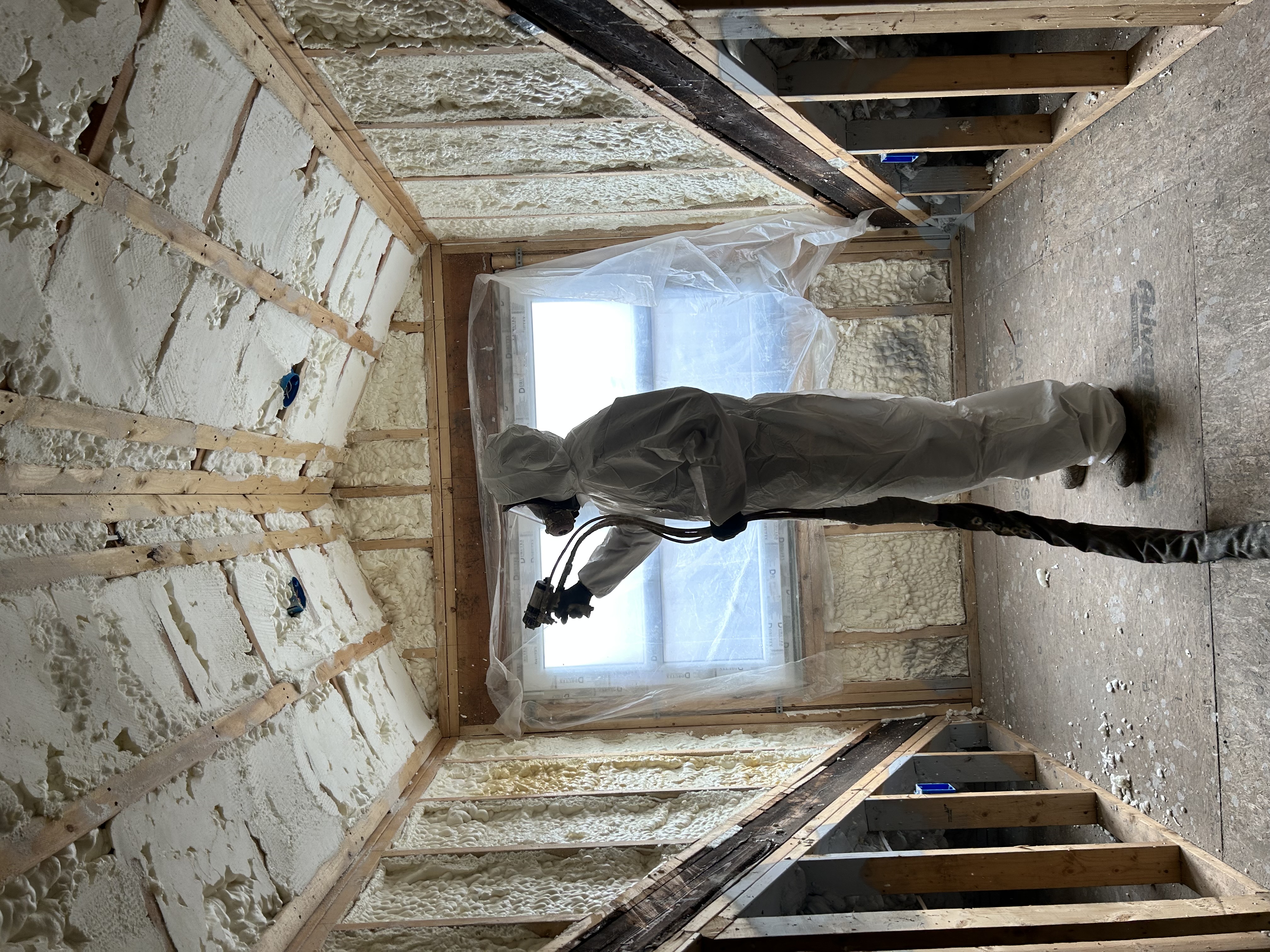 Professional spray foam insulation application in an attic by South Shore Spray Foam technician